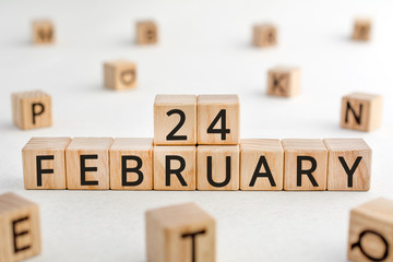 February 24 - from wooden blocks with letters, important date concept, white background random letters around