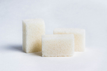 three cubes of white sugar on a white background
