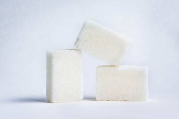 three cubes of white sugar on a white background