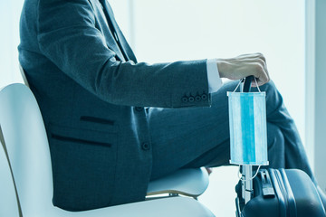 businessman with a suitcase and a surgical mask