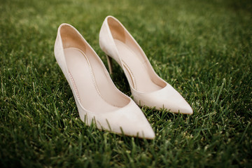 Fototapeta premium Wedding shoes of the bride. Standing on the green grass.