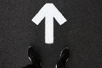 A man is standing on the road. Forward arrow