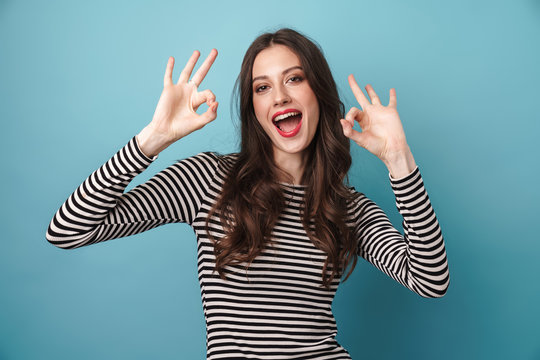 Image of excited caucasian woman smiling and gesturing ok sign