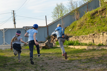 Children have fun playing in the yard. The kids are racing ahead. Fun active sports and leisure