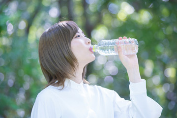 屋外で水を飲む女性