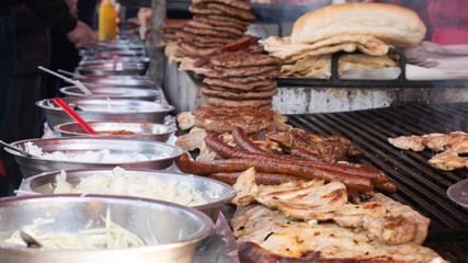 Grilling various types of meat. Preparation of burgers, sausages and meat at street.