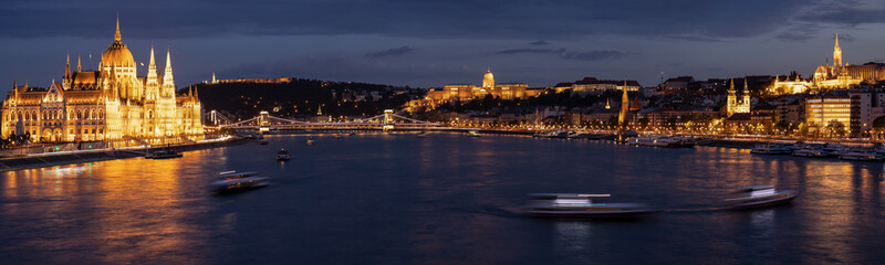 Naklejka na ściany i meble Budapest panorama at night with Parliament building and castle illuminated by city lights and reflection in the danube river.