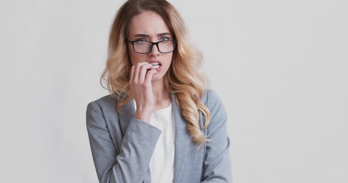 Worried, stressed young business woman biting her nails
