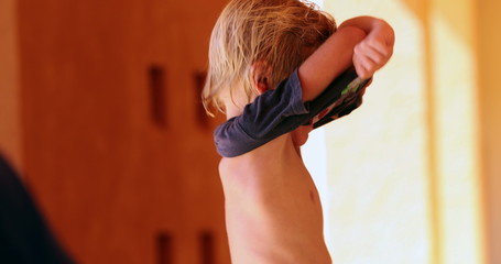 Little boy getting dressed kid putting and removing t-shirt