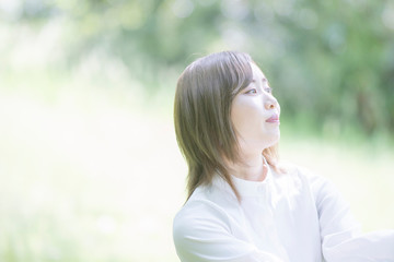 緑あふれる公園でくつろぐ女性