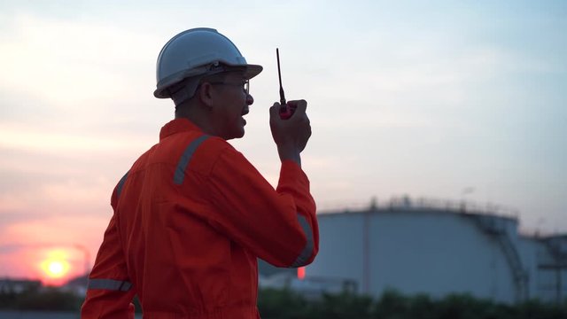 Asian engineer control work with radio communication at twilight time