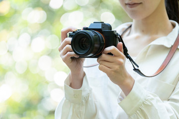 自然の中でカメラを構える若い女性