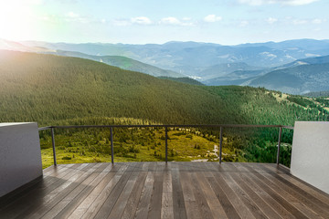 Luxury terrace in the mounting house. Balcony view of mountains. Background with beautiful landscape. Sunny Day. Terrace with a beautiful view.