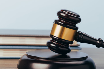 Judge Gavel with books on a wooden table and a blue background. The concept of law.