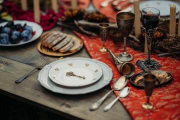 Antique dishes and iron wine glasses on the table with food