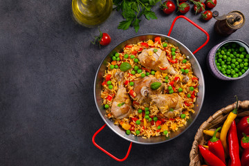 Arroz con pollo. Baked pieces of chicken with bone, rice with paprika and peas.