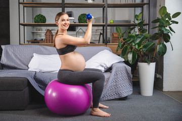 Fototapeta premium Pregnant woman is doing exercises with gymnastic ball