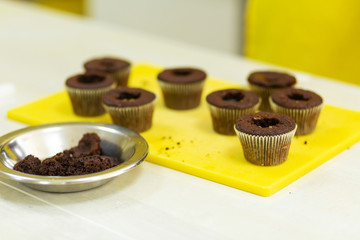 The process of making chocolate cupcakes with sweet cream. Creation of cakes by professional pastry chefs