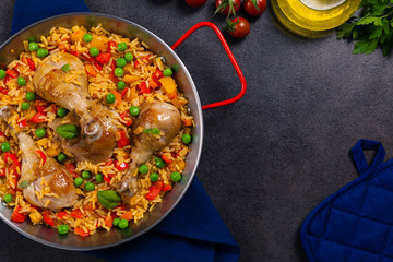 Arroz con pollo. Baked pieces of chicken with bone, rice with paprika and peas.