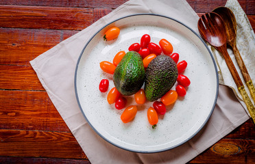 Appetizing avocados and orange and red tomatoes ready to make a salad.