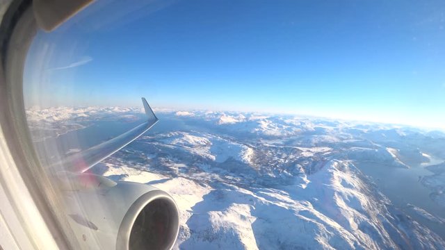 Aerial view over the snowy mountains of Northern Norway in the Arctic Circle during a beautiful winter day.
