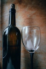 Bottle of wine, glass and grapes on a wooden background