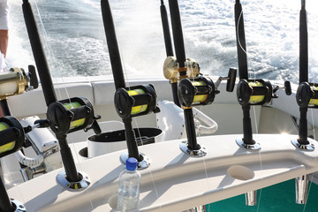 Spinning rods with reels installed in holders before fishing on a boat