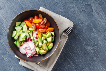 Vegan buddha bowl. Healthy vegetarian salad with cherry tomatoes, cucumber, radish,, avocado and lettuce.