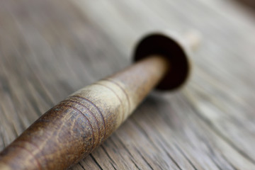Fototapeta premium an old knitting spindle on a structural table made of cracked wood