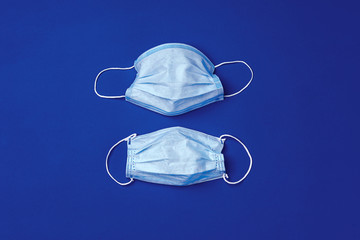 Medical face mask on blue background. Coronavirus covid-19 prevention concept