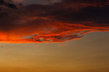 Black thunderclouds at sunset. Bright orange sunset and dark clouds. Storm sky