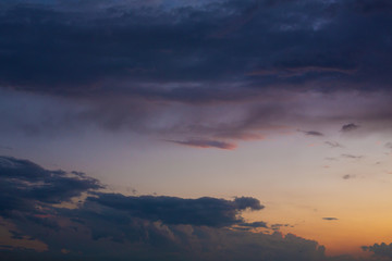 Black thunderclouds at sunset. Bright orange sunset and dark clouds. Storm sky