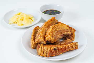 Deep Fried Crispy Streaky Pork Belly Thai and Chinese Food on White Plate with Sauce and Ginger on White Background Isolated.