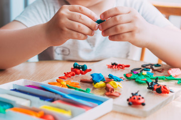 Child's hands sculpt figures from soft colorful plasticine. Educational and entertaining classes with children. Close-up