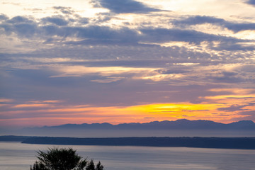sunset over the sea with mountains in the background