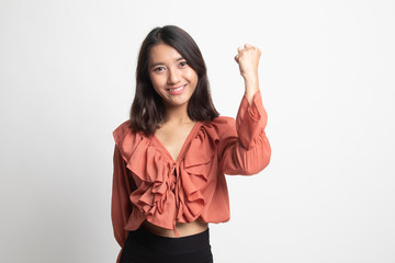 Successful  young Asian woman hold fist up .