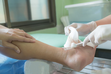 Doctor bandaging leg of patient in hospital.Health and medical concept.