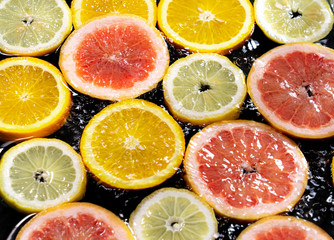 slices of fruit in water on a black background