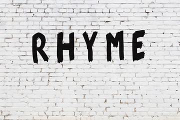 Word rhyme painted on white brick wall
