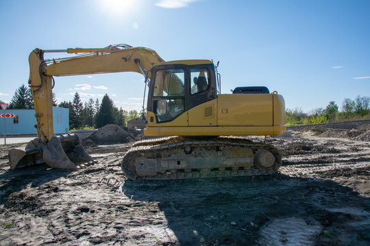 The Excavator Works On A Construction Site.Construction Machinery For Excavating, Loading, Lifting And Hauling Of Cargo On Job Sites