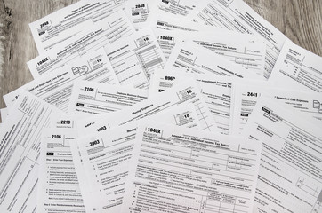 different tax forms 1040 on a wooden table