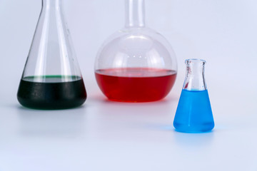 Laboratory glassware with liquid on white background. glass chemical flask with reagent.
