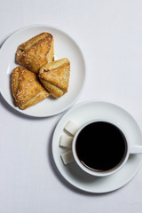 Confectionery baking and a cup of coffee on a white tablecloth. Tea set is also white