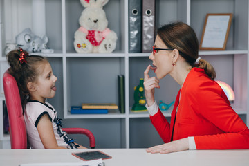 Voice ability problem concept. Language therapist teaching stuttering cute preschooler child girl...