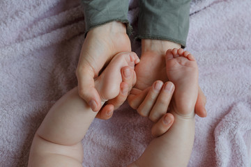 Baby feet in mother hands. Mom and her Child. Masseur massaging little baby's foot. Happy Family concept. Beautiful conceptual image of Maternity