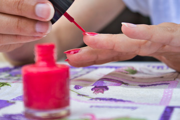 Woman painting his nails red
