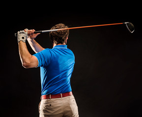 Close-up of a golf player perfecting the swing isolated on dark background