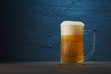 Beer in mug on blue background