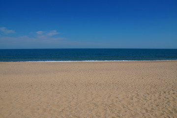 Fototapeta na wymiar empty beach in the summer - sea, sand, white waves 