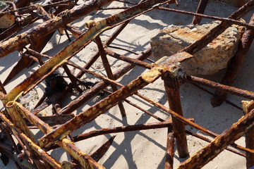 Fototapeta na wymiar rusty metal construction in the sand 